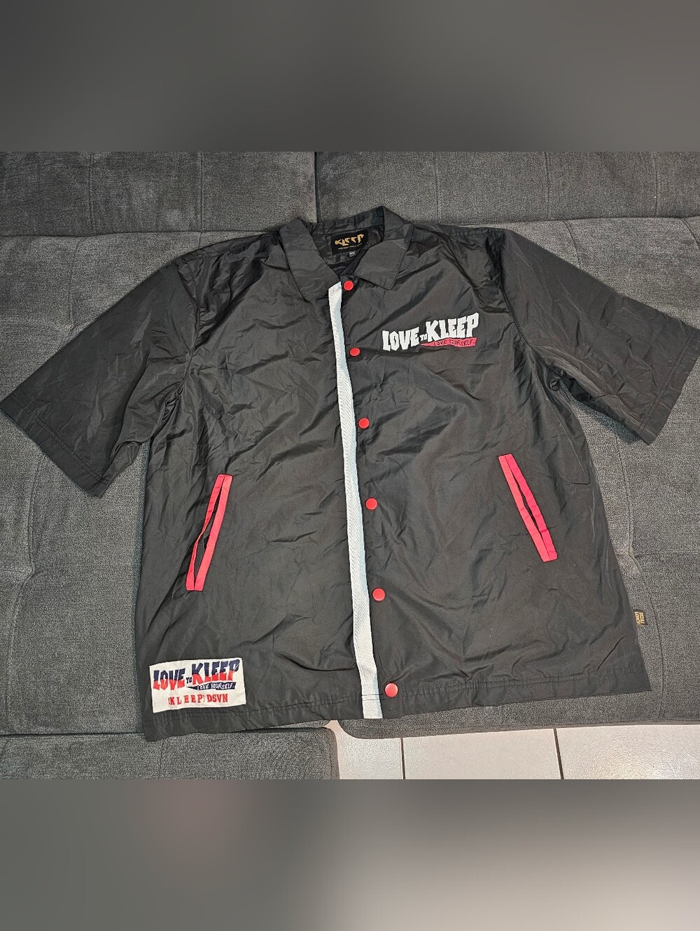 Black Short-Sleeve Coach Jacket with Red Trim
